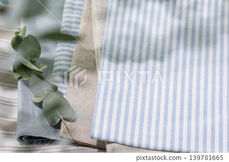 Striped Cotton Napkins On Linen Tablecloth With Eucalyptus Branch Striped Cotton Napkins On Linen Tablecloth With Eucalyptus Branch 139781665