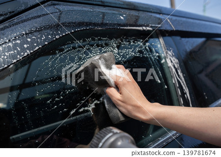 A man washing the car windows 139781674