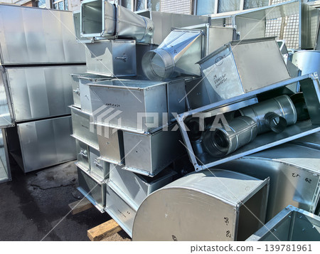 Industrial metal ducts piled high in a bustling construction site Industrial metal ducts piled high in a bustling construction site 139781961