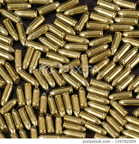 Many brass gun bullets on black table closeup view from above Many brass gun bullets on black table closeup view from above 139782009