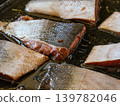 Pieces of salmon with skin in cooking oil and some herbs on frying pan - to be baked, closeup detail 139782046