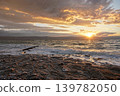 Sun shines through dramatic sunset clouds to waves at Jordanian side of Dead Sea 139782050