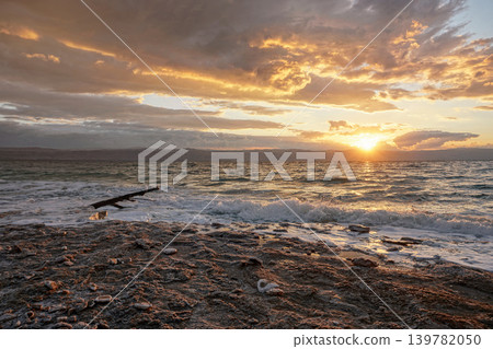 Sun shines through dramatic sunset clouds to waves at Jordanian side of Dead Sea Sun shines through dramatic sunset clouds to waves at Jordanian side of Dead Sea 139782050