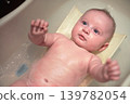 Infant baby boy washed in small bath tub, view from above 139782054