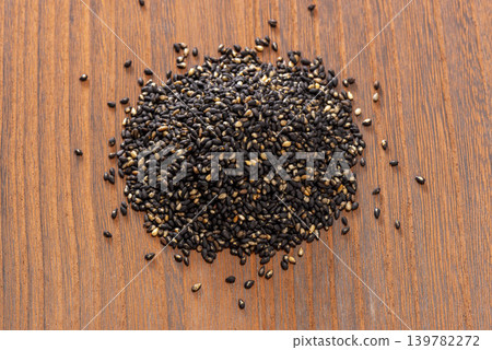 A photo of healthy food with black sesame seeds scattered on a wooden table. 139782272