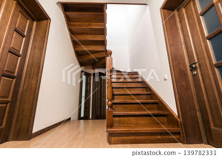 Modern brown oak wooden stairs and doors in new renovated house interior Modern brown oak wooden stairs and doors in new renovated house interior 139782331
