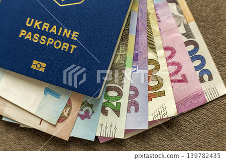 Ukrainian passport and money, Ukrainian hryvna banknotes bills on copy space background, top view. Traveling and finance problems concept. Ukrainian passport and money, Ukrainian hryvna banknotes bills on copy space background, top view. Traveling and finance problems concept. 139782435