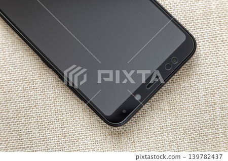New black modern cellphone isolated on light cloth copy space background. Modern technology, communication and gadget design concept. 139782437