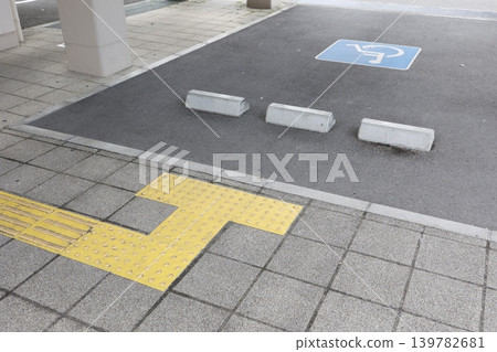 點字指示牌和殘障人士專用停車位。鋪設路面的道路上設有殘障福利設施設備。 點字指示牌和殘障人士專用停車位。鋪設路面的道路上設有殘障福利設施設備。 139782681