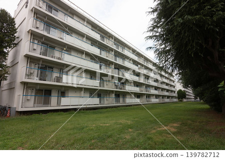 A retro Showa-era atmosphere: A nostalgic public housing complex nestled in a lush green area. A retro Showa-era atmosphere: A nostalgic public housing complex nestled in a lush green area. 139782712