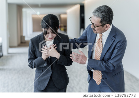 A businesswoman clutching her chest in pain. A businesswoman clutching her chest in pain. 139782778