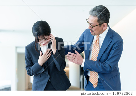 一位女商人痛苦地摀著頭。 一位女商人痛苦地摀著頭。 139782802
