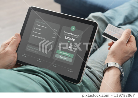 Man Holding Tablet with Payment Successful Screen at Home Man Holding Tablet with Payment Successful Screen at Home 139782867