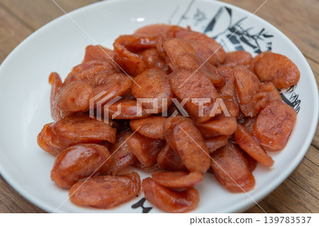 Closeup fried sliced kun chiang sausage on white plate glossy texture savory Asian food ingredient traditional preserved pork Closeup fried sliced kun chiang sausage on white plate glossy texture savory Asian food ingredient traditional preserved pork 139783537