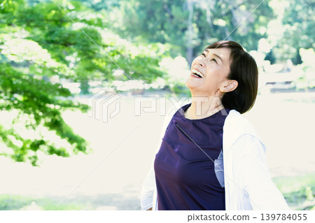 Middle-aged women refreshing themselves outdoors Middle-aged women refreshing themselves outdoors 139784055