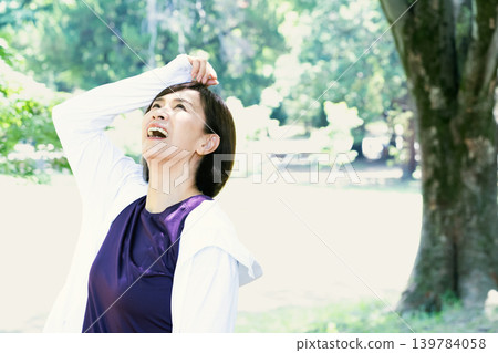 Middle-aged women refreshing themselves outdoors Middle-aged women refreshing themselves outdoors 139784058