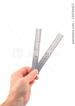male hand holding two metal rulers on white background 139784427