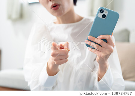 Angry woman holding a smartphone 139784797
