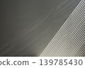 The background shows the interplay of light and shadow cast by blinds shining diagonally into the wall. 139785430