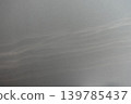 A smooth gray wall background material that reflects soft ripples of light. 139785437