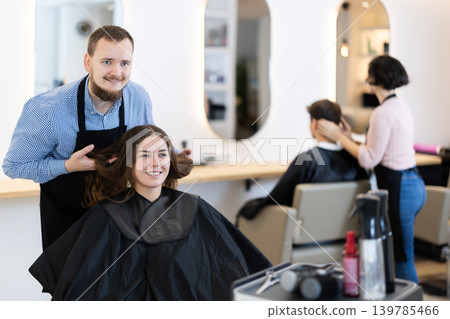 Young male hairdresser discussing haircut of female client 139785466