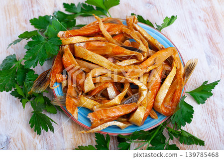 Smoked salmon belly strips on plate on wooden table 139785468
