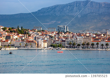 A Croatian seaside town nestled against a mountain range. 139785523