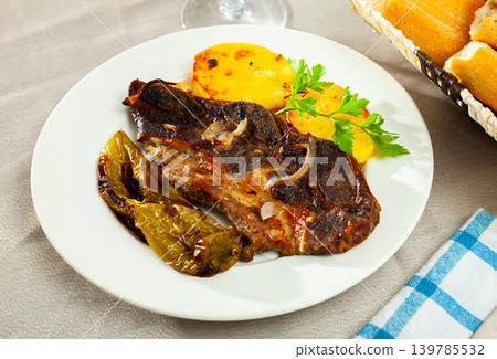 Tasty beef baked with potatoes and stewed peppers served Tasty beef baked with potatoes and stewed peppers served 139785532
