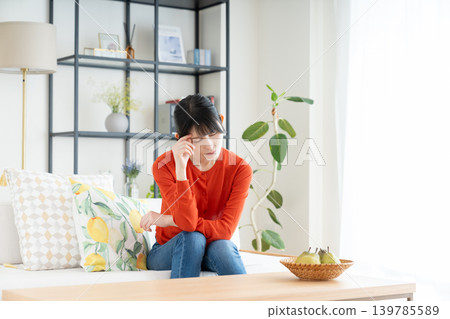 A middle-aged woman who worries in the living room A middle-aged woman who worries in the living room 139785589