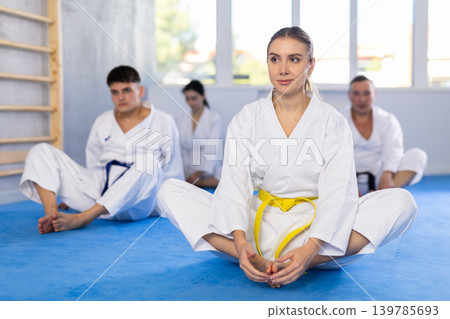 Group of people practicing butterfly pose in studio Group of people practicing butterfly pose in studio 139785693