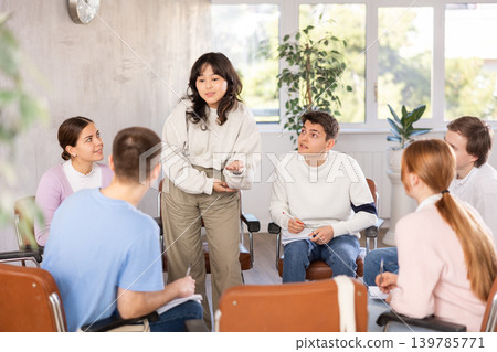 Young woman teacher conducting lesson with group of students Young woman teacher conducting lesson with group of students 139785771