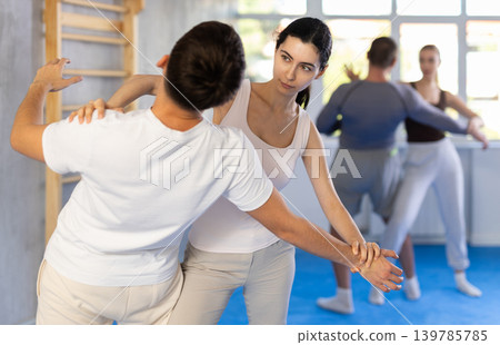 Young woman and guy training self-defense techniques 139785785