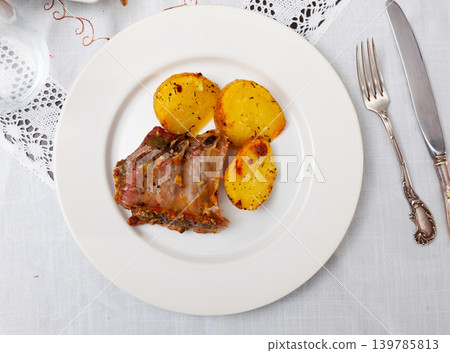 Roasted pork ribs with side dish of fried potatoes Roasted pork ribs with side dish of fried potatoes 139785813
