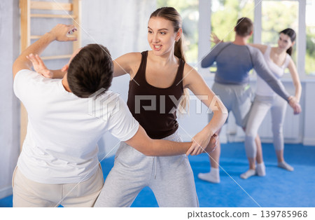 Young woman and guy training self-defense techniques 139785968