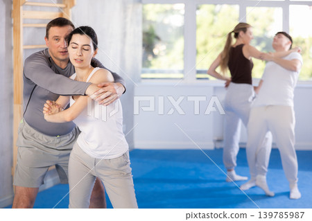 Woman practices blows to the head of a male attacker during self defense training Woman practices blows to the head of a male attacker during self defense training 139785987