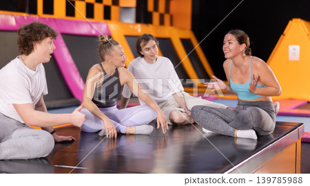 Two women and two teenager boys talking in trampoline center Two women and two teenager boys talking in trampoline center 139785988