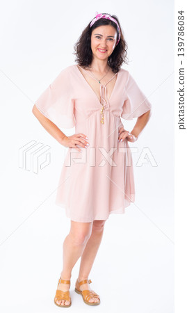 Portrait of an attractive adult woman in a pink dress on white background Portrait of an attractive adult woman in a pink dress on white background 139786084