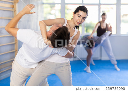 Woman practices blows to the head of a male attacker during self defense training Woman practices blows to the head of a male attacker during self defense training 139786090