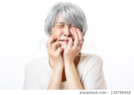 A lamenting, gray-haired senior woman A lamenting, gray-haired senior woman 139786408