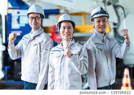 三名身穿工作服的男子在一輛特種車輛前擺出威風凜凜的勝利姿勢。 三名身穿工作服的男子在一輛特種車輛前擺出威風凜凜的勝利姿勢。 139786822