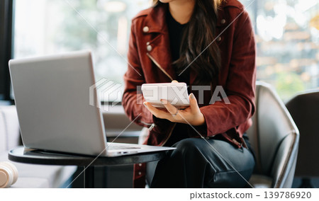 Women counting coins on calculator taking from the piggy bank. hand holding pen working on calculator to calculate on desk about cost Women counting coins on calculator taking from the piggy bank. hand holding pen working on calculator to calculate on desk about cost 139786920