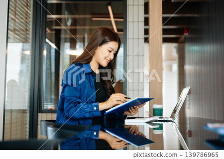 Business woman using tablet and laptop for doing math finance on an office desk, tax, report, accounting, statistics, and analytical research concept in office 139786965