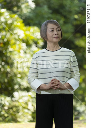 幾位老年婦女在綠樹環繞的公園散步。 幾位老年婦女在綠樹環繞的公園散步。 139787145