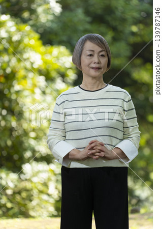幾位老年婦女在綠樹環繞的公園散步。 幾位老年婦女在綠樹環繞的公園散步。 139787146