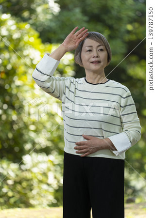 幾位老年婦女在綠樹環繞的公園散步。 139787150