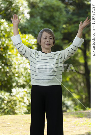 Senior women strolling in a park surrounded by fresh greenery. 139787157