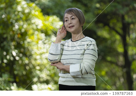 幾位老年婦女在綠樹環繞的公園散步。 幾位老年婦女在綠樹環繞的公園散步。 139787163