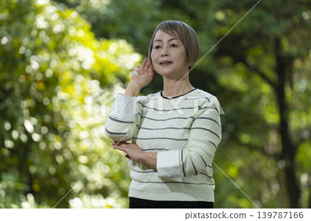 幾位老年婦女在綠樹環繞的公園散步。 幾位老年婦女在綠樹環繞的公園散步。 139787166