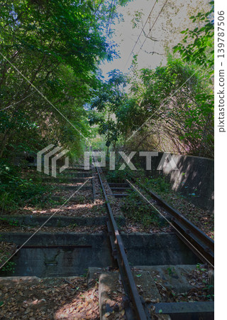 The abandoned railway tracks and stone steps surrounded by greenery remain at the site of the former Yashima Cable Car (Yashima Mountain Railway) in Takamatsu City, Kagawa Prefecture. 139787506