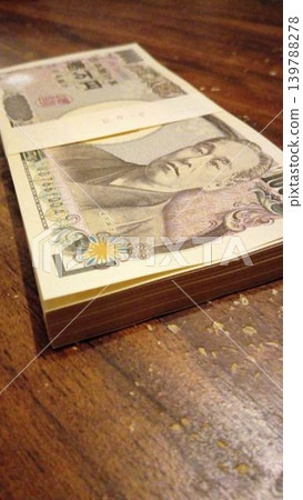 A stack of 1 million yen bills placed on the desk. A stack of 1 million yen bills placed on the desk. 139788278